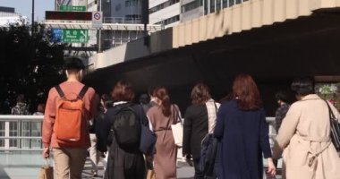Shibuya 'daki şehir şehrinde yürüyen insanların yavaş çekimleri.