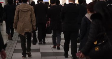 Shinagawa 'nın el bilgisayarlı kentindeki ofis çalışanlarının ağır çekimde yürümesi.