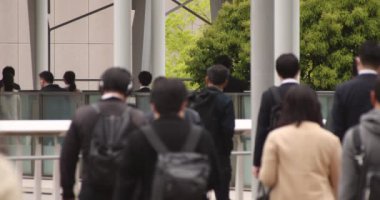 Shinagawa kentindeki ofis çalışanlarının ağır çekimde yürümesi.