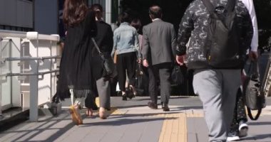 Shibuya 'daki şehir şehrinde yürüyen insanların yavaş çekimleri.