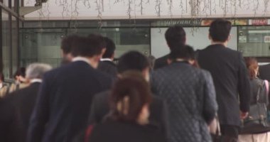 Shinagawa kentindeki ofis çalışanlarının ağır çekimde yürümesi.