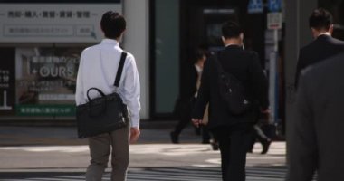 Tokyo 'daki şehir şehrinde yürüyen insanların yavaş çekimleri.