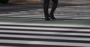 Tokyo kentindeki yürüyen insanların vücut parçalarının yavaş çekimleri.