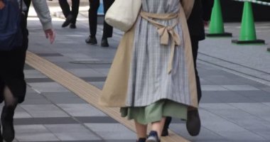 Tokyo kentindeki yürüyen insanların vücut parçalarının yavaş çekimleri.