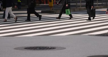 Tokyo kentindeki yürüyen insanların vücut parçalarının yavaş çekimleri.