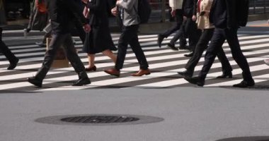 Tokyo kentindeki yürüyen insanların vücut parçalarının yavaş çekimleri.