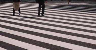 Tokyo kentindeki yürüyen insanların vücut parçalarının yavaş çekimleri.