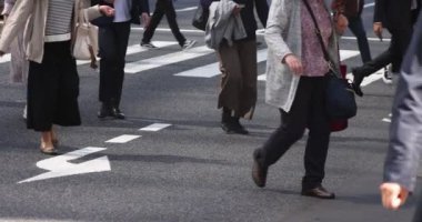 Tokyo kentindeki yürüyen insanların vücut parçalarının yavaş çekimleri.