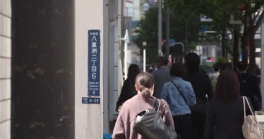 Tokyo 'daki şehir şehrinde yürüyen insanların yavaş çekimleri.