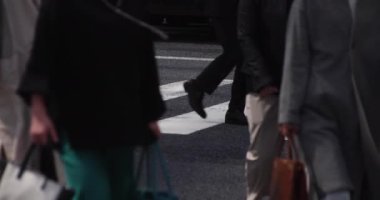 Tokyo kentindeki yürüyen insanların vücut parçalarının yavaş çekimleri.