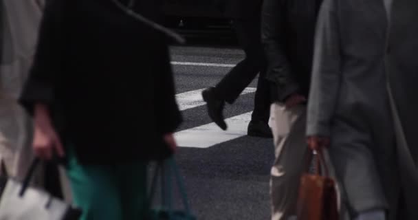 Una cámara lenta de partes del cuerpo de personas que caminan en la ciudad urbana de Tokio — Vídeo de stock