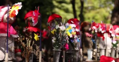 Jizo heykeli ile rengarenk yel değirmenlerinin yavaş çekimleri.