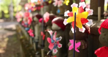 Jizo heykeli ile rengarenk yel değirmenlerinin yavaş çekimleri.