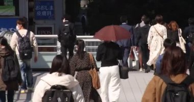 Shibuya 'daki şehir şehrinde yürüyen insanlar.