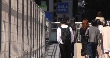 Shibuya 'daki şehir şehrinde yürüyen insanlar.
