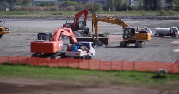 Grúas en miniatura en movimiento en el turno de inclinación diurno en construcción — Vídeos de Stock