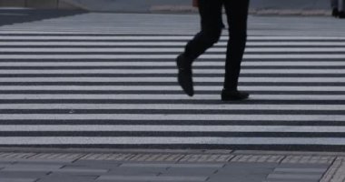 İş kasabasındaki yaya geçidinde yürüyen insanların vücut parçalarının yavaş çekimleri.