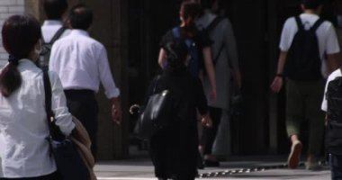 Tokyo kentindeki yürüyen insanların vücut parçalarının yavaş çekimleri.