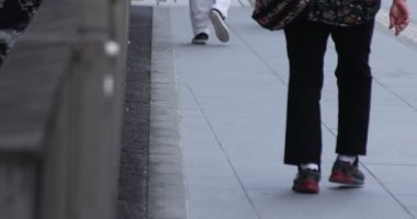 Tokyo kentindeki yürüyen insanların vücut parçalarının yavaş çekimleri.