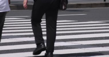 İş kasabasındaki yaya geçidinde yürüyen insanların vücut parçalarının yavaş çekimleri.