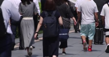 Tokyo kentindeki yürüyen insanların vücut parçalarının yavaş çekimleri.