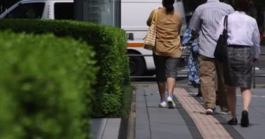 Tokyo kentindeki yürüyen insanların vücut parçalarının yavaş çekimleri.