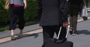 Tokyo kentindeki yürüyen insanların vücut parçalarının yavaş çekimleri.