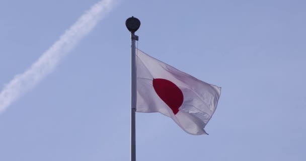 A slow motion of Japanese flag behind the blue sky — Wideo stockowe