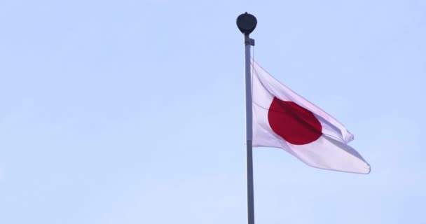 Un lent mouvement du drapeau japonais derrière le ciel bleu — Video