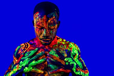 Ultraviyole vücut sanatıyla stüdyoda poz veren Afro-Amerikan bir adam.