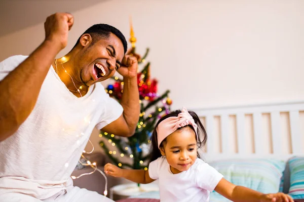 Familia de raza mixta pasar vacaciones en la cama en la mañana de Navidad dormitorio — Foto de Stock