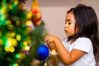 Melez küçük şirin kız Noel sabahı uyandı yatak odasında ve bir dilek diliyor.