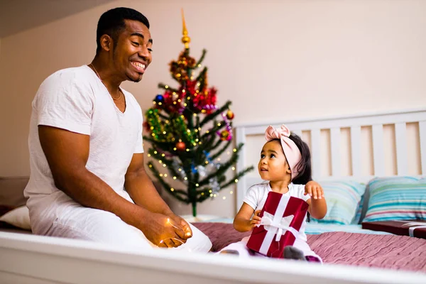 Feliz padre de raza mixta y hermoso niño en la feliz mañana de x-mas en el dormitorio — Foto de Stock