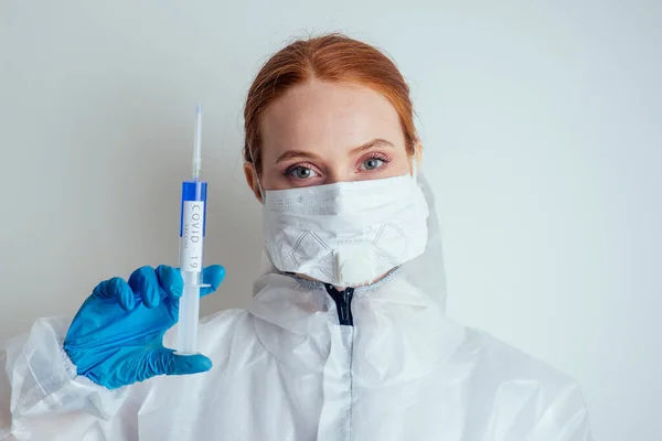 Mulher virologista em máscara de proteção química, óculos e luvas segurando vacina potencial no laboratório — Fotografia de Stock