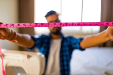 Stüdyoda dikiş makinesinde elbise diken Arap bir tasarımcı.