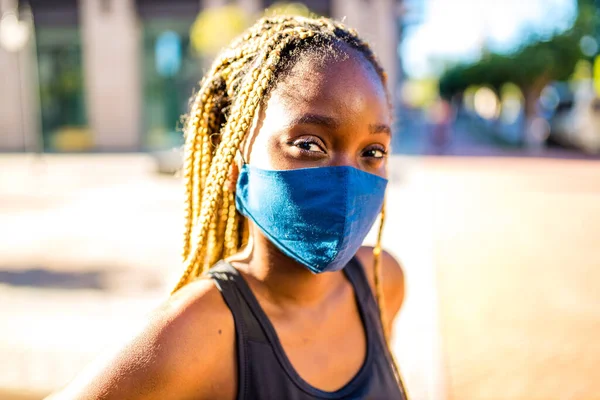 Afroamerikanerin mit langen gelben Dreadlocks, Zöpfen, die draußen mit Maske in der Stadt arbeiten — Stockfoto
