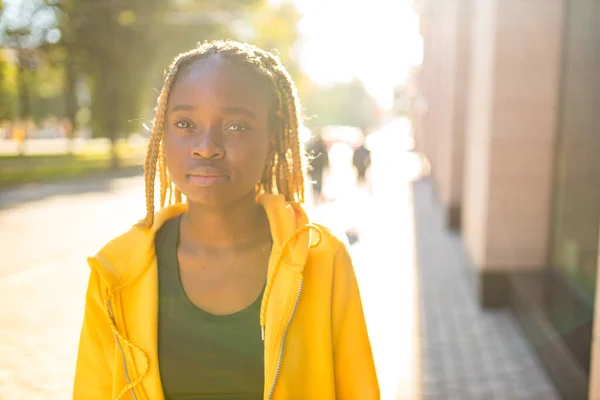 Afrikanisch-amerikanische Frau mit langen gelben Dreadlocks Zöpfen, die traurig und einsam in der Straße von sity aussehen — Stockfoto