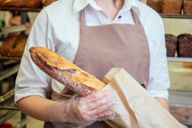 Neşeli fırıncı müşteriye ekmek getiriyor.