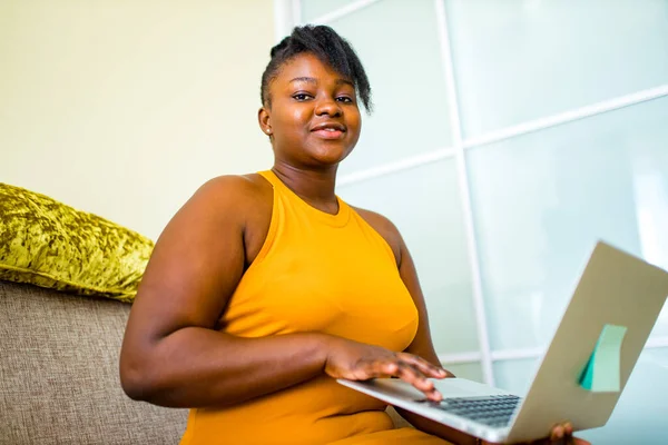 Женщина смешанной расы работает на ноутбуке в гостиной — стоковое фото
