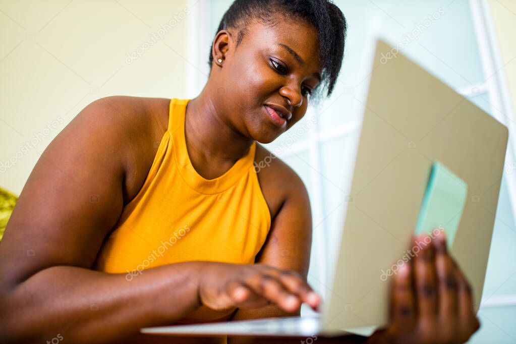 mixed race woman working by laptop in living room