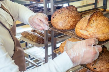 Neşeli fırıncı müşteriye ekmek getiriyor.