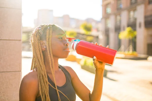 Αφροαμερικανή γυναίκα που πίνει smoothies αφού έκανε τζόκινγκ στους δρόμους του κέντρου — Φωτογραφία Αρχείου