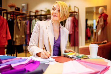 Genç stilist müşteriye kıyafet rengi seçmesinde yardım ediyor