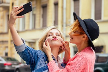 Mutlu kadınlar Avrupa sokaklarında sosyal ağ uygulaması toplantı web sitesi kullanarak selfie çekiyorlar.