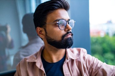 Düşünceli Hintli adam gözlük takıyor ve depresyona bakıyor.