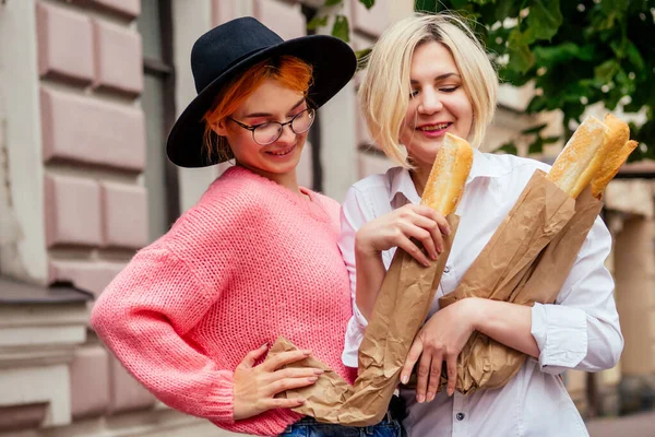 Счастливые женщины, пользующиеся приложением социальной сети для встреч на улице в Европе — стоковое фото