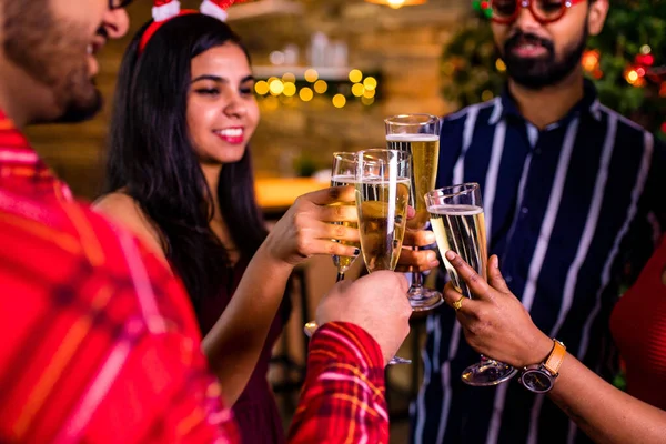 Gruppe von vier indischen Freunden jubelt mit Champagner-Flöten und sieht glücklich aus, während sie Party in der Küche zu Hause bleiben Quarantäne Coronavirus Ausbruch Party — Stockfoto