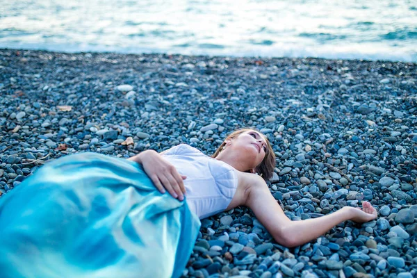 Красивая длинноволосая женщина, одетая как русалка, сидит на песчаном фоне Лицензионные Стоковые Изображения