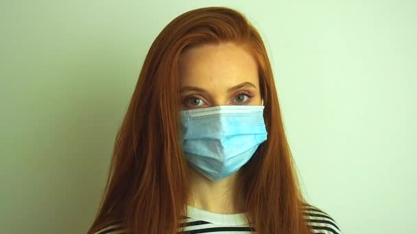 若い女性は保護白い医療用マスクを身に着けています,コロナウイルスの流行のために準備医療用手袋やメガネを置きます — ストック動画