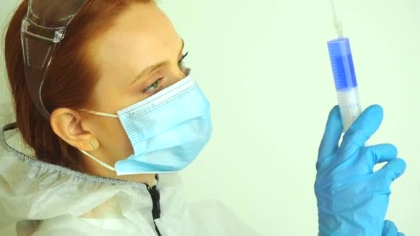 Viroloog vrouw in chemische bescherming masker, bril en handschoenen met potentieel vaccin in het lab — Stockvideo